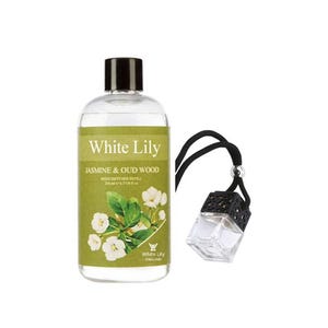 May include: A clear glass bottle with a black cap and a green label that says "White Lily Jasmine & Oud Wood Reed Diffuser Refill 200 ml/6.7 fl oz". The bottle is next to a black and clear glass car air freshener with a black string.