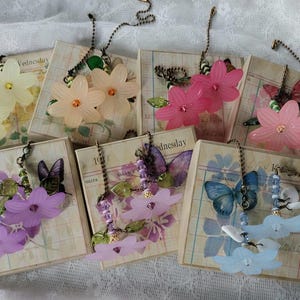 May include: A set of three ceramic mugs with a speckled, matte finish. The mugs are in shades of cream, light gray, and dark gray. Each mug has a simple, minimalist design and a rounded handle. The mugs are likely for coffee or tea.