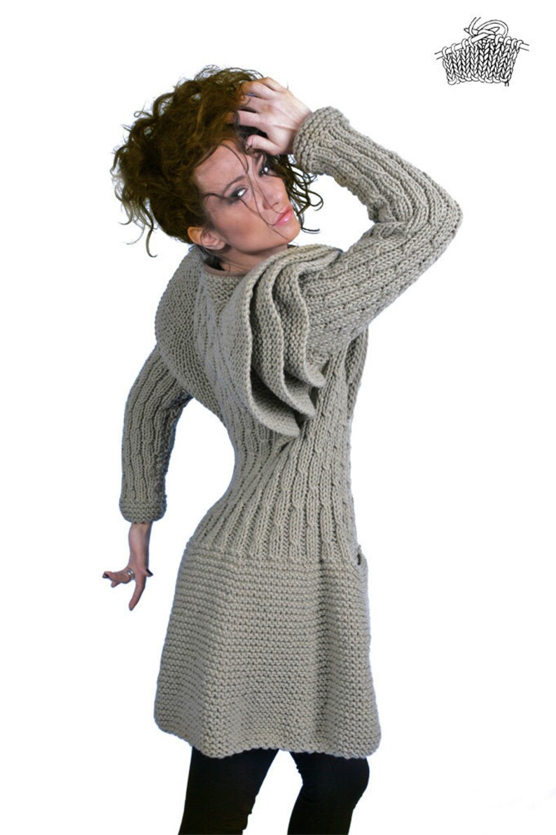 May include: A grey knitted dress with a hooded neckline and a unique design on the sleeves. The dress has a fitted bodice and a flowing skirt.