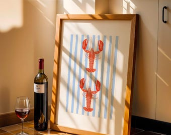 May include: A framed art print featuring two red lobsters on a blue and white striped background. A bottle of red wine and a wine glass are in the foreground. The print is in a wooden frame.