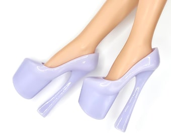 May include: A pair of lavender platform high heels with a smooth, glossy finish and thick, curved heels. The text below reads: ATOMIC PLATFORMS, LAVENDER, FITS FASHION ROYALTY & NUFACE. These shoes are designed for miniature doll figures.