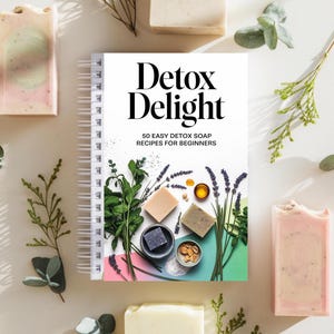 May include: A closed spiral bound book titled "Detox Delight: 50 Easy Detox Soap Recipes for Beginners" with a colorful cover featuring various ingredients and soaps.