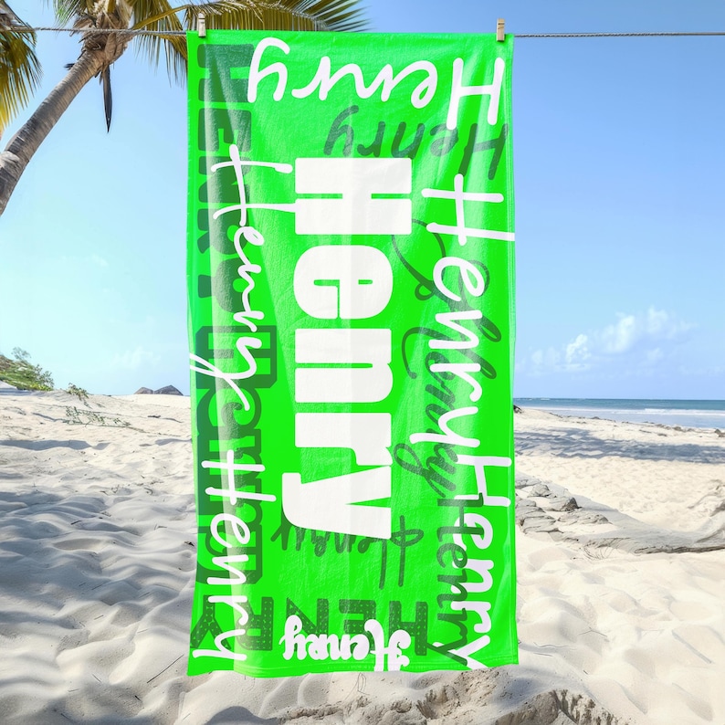 Bright green personalized beach towel with the name Henry in various fonts, hanging on a line at the beach with palm trees and sand. Custom name towel, perfect for pool, swim, or summer trips for all ages.