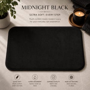Puede incluir: Una alfombra de baño rectangular de color negro medianoche. La alfombra es suave y absorbente, diseñada para el baño. El texto en la imagen dice "MIDNIGHT BLACK" y "ULTRA SOFT. EVERY STEP."