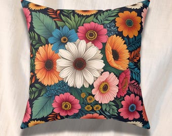 Könnte beinhalten: Quadratisches Zierkissen mit einem lebendigen Blumenmuster. Das Design zeigt einen dunkelblauen Hintergrund mit bunten Blumen in Rosa-, Orange-, Blau- und Weißtönen. Grüne Blätter und Akzente ergänzen das botanische Thema und schaffen einen fröhlichen und dekorativen Akzent.