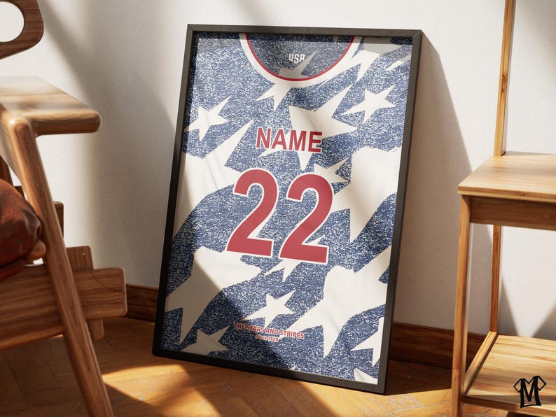 May include: Framed print of a jersey design with a distressed look. The jersey features a blue and white star pattern, with the word "NAME" above the number "22" in red. The word "USA" is at the top.