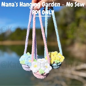 Pode incluir: Três floreiras de jardim suspensas feitas à mão em cores pastel. Cada floreira é preenchida com flores coloridas e fofas. As floreiras são suspensas por cordas correspondentes. O texto "Nana's Hanging Garden - No Sew PDF ONLY" é visível no topo da imagem.