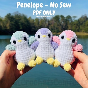 May include: Three handmade crochet penguin toys in pastel colors: mint, lavender, and pink. Each penguin has a white body, yellow feet, and black eyes. The text "Penelope - No Sew PDF ONLY" is visible.