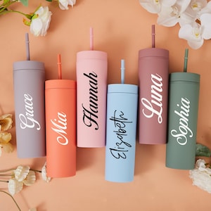 May include: Six colorful tumblers with straws, each featuring a different name in a stylish font: Grace, Mia, Hannah, Elizabeth, Luna, and Sophia. The tumblers are in shades of gray, coral, pink, light blue, mauve, and green.