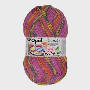 Puede incluir: Ovillo de lana Opal Beauty en tonos rosa, amarillo, naranja y gris. La etiqueta presenta una taza de té, galletas y el texto "TeaTime". El ovillo pesa 100g y mide aproximadamente 425m.