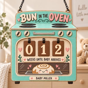 Puede incluir: Un letrero de cuenta regresiva de madera con forma de estufa vintage en color verde azulado y crema. Incluye el texto "BUN IN THE OVEN" y "WEEKS UNTIL BABY ARRIVES" con "BABY MILLER" en la parte inferior. Tres tarjetas marrones muestran el 012.