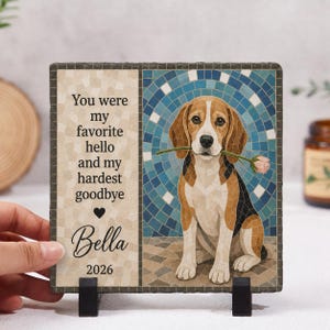 May include: A square slate plaque featuring a mosaic-style illustration of a beagle holding a pink rose in its mouth. The left side displays the text: You were my favourite hello and my hardest goodbye, the name Bella, and the year 2026.