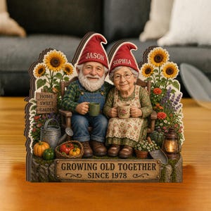 May include: Wooden garden-themed decoration featuring a seated elderly couple dressed as gnomes, holding mugs. The gnomes wear red hats with names, surrounded by sunflowers, flowers, and a sign that reads "Growing Old Together Since 1978."
