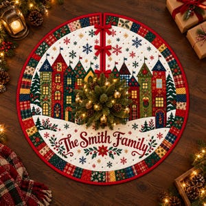 May include: A round quilted Christmas tree skirt featuring a colorful village scene with houses, pine trees, and snowflakes. The text "The Smith Family" is printed in red script. The border consists of a patchwork pattern in red, green, and blue.