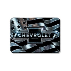 Peut inclure: Un logo Chevrolet argenté avec le mot "CHEVROLET" en lettres noires, superposé à un drapeau américain argenté et noir.