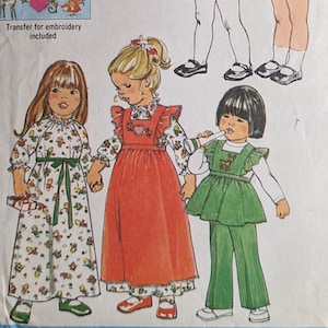 Pode incluir: Padrão de costura Simplicity número 9511 para vestidos de meninas pequenas. O padrão inclui quatro designs de vestidos diferentes, com um vestido vermelho com uma aplicação em forma de coração, um vestido verde com uma aplicação em forma de veado, um vestido branco com uma aplicação floral e um vestido xadrez vermelho e branco. O padrão inclui uma transferência para bordado.