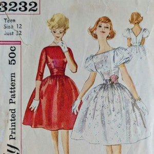 May include: Vintage Simplicity sewing pattern for a teen dress, pattern number 3232, size 12, bust 32. The pattern includes two dress styles, one red and one white with floral print. The pattern is printed on white paper with black text and illustrations.
