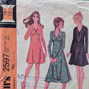 May include: Vintage sewing pattern for a dress in three styles. The pattern is for misses' sizes 12-24, bust 34. The pattern is called McCall's 2597 and is printed on a light brown background with a black and white illustration of three women wearing the dress.