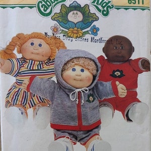 May include: A vintage sewing pattern for Cabbage Patch Kids clothes. The pattern shows three dolls wearing different outfits. The pattern is titled "Cabbage Patch Kids" and has the number 6511 printed on it. The text "Drug Stores Northwest, Inc." is also printed on the pattern. The pattern is for clothes and is from the company Butterick.
