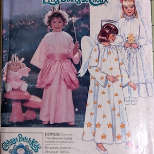 May include: Vintage Butterick sewing pattern for Cabbage Patch Kids costumes. The pattern features illustrations of children in princess, angel, and bridal outfits. The cover is predominantly pink and white, with the text "P'tits Bouts de Choux" and "Cabbage Patch Kids".