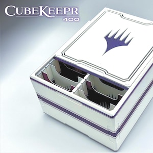 May include: White and purple CubeKeepr 400 storage box with a lid featuring a purple emblem. The box has a rectangular shape with purple stripes and internal compartments. The text "CubeKeepr 400" is visible on the top left.
