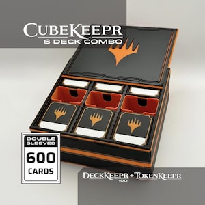 Könnte beinhalten: Eine schwarze und orangefarbene Kartenaufbewahrungsbox mit der Aufschrift CUBEKEEPR 6 DECK COMBO, DECKKEEPR + TOKENKEEPR 100 und DOUBLE SLEEVED 600 CARDS. Die Box hat einen offenen Deckel und sechs Fächer, von denen drei Kartendecks enthalten.