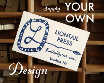 Könnte beinhalten: Eine weiße Visitenkarte mit blauer Schrift und einer blauen Grafik eines stilisierten Buchstabens L. Der Text auf der Karte lautet "Liontail Press", "liontailpress.com" und "Brooklyn, NY". Der Text "Supply Your Own Design" ist in Weiß auf einem Holzgrund geschrieben.