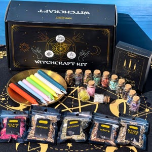 Puede incluir: Un kit de brujería que incluye una caja negra grande con gráficos celestiales dorados, una bandeja dorada con siete velas cónicas de colores, numerosos frascos de vidrio con hierbas y cristales, y cinco bolsas etiquetadas con plantas secas.