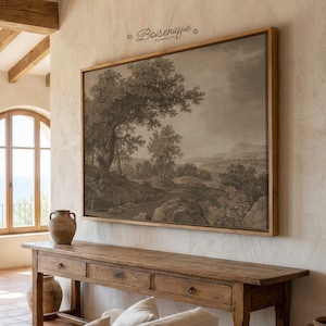 May include: A large framed landscape print in sepia tones hangs on a beige wall. The artwork depicts trees, rocks, and a distant mountain range. A wooden console table with drawers sits below the artwork. The text "Boisenique" is in the upper right corner.