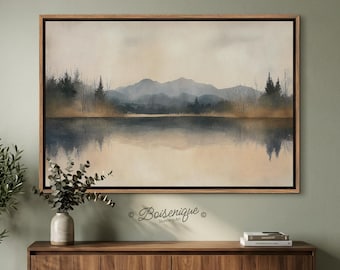 May include: A framed landscape art print featuring a serene lake scene with mountains in the background. The artwork uses muted tones of blue, brown, and beige, creating a calming atmosphere. The print is displayed above a wooden cabinet.