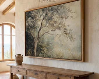 May include: A large framed canvas art piece depicting a tree with a muted color palette of greens, browns, and blues. The artwork hangs above a long, wooden console table with three drawers. The room has a rustic, natural aesthetic.