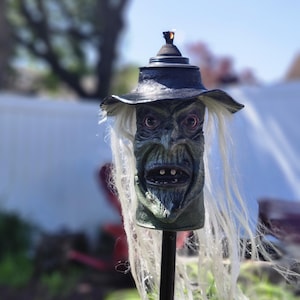 La Bruja - Antorcha Tiki Monstruosa: una pieza única y escalofriante, perfecta para Halloween o para disfrutar del terror todo el año. Imprescindible para acampar.
