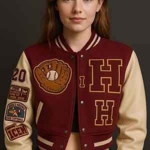 Peut inclure: Veste universitaire bordeaux et crème coupée, avec la lettre "H" dorée. La veste présente un écusson de gant de baseball et d'autres écussons sur les manches. La veste a une fermeture boutonnée et des poignets rayés.