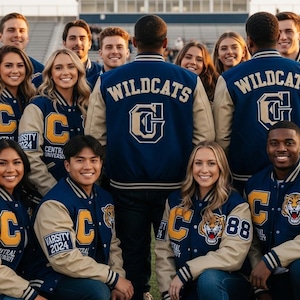 Könnte beinhalten: Eine Gruppe von Personen in marineblauen und beigefarbenen Collegejacken. Auf den Jacken steht das Wort "Wildcats" auf dem Rücken. Die Jacken haben den Buchstaben "C", die Wörter "Central University" und "Varsity 2024". Einige Jacken zeigen eine Tigergrafik und die Nummer "88".
