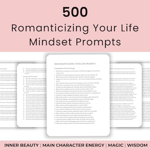 May include: A stack of white cards with text, titled "500 Romanticizing Your Life Mindset Prompts." The cards are arranged in a fan shape, with the central card displaying a list of prompts. The background is a soft pink.