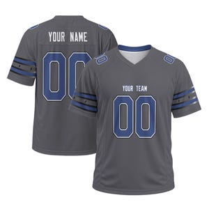 May include: A charcoal gray sports jersey featuring a V-neck collar, short sleeves with blue and black stripes, and the text YOUR NAME and YOUR TEAM printed in white above the number 00 in blue with white outlines on the front and back.