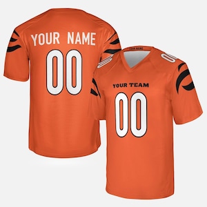 May include: An orange short-sleeved sports jersey featuring black tiger-stripe patterns on the sleeves. The front displays the text YOUR TEAM and the number 00 in white. The back shows the text YOUR NAME and the number 00 in white.