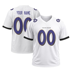 May include: A white sports jersey with short sleeves and a V-neck collar. The front features the text YOUR TEAM and the number 00 in purple with gold outlines. The back displays the text YOUR NAME and the number 00 in purple with gold outlines.