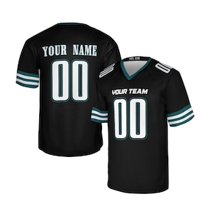 Könnte beinhalten: Schwarzes Football-Trikot mit weißen Zahlen und Schriftzügen. Das Trikot hat ein türkis-weißes Streifendesign an den Ärmeln und am Kragen. Der Text "YOUR NAME" und "YOUR TEAM" ist sichtbar.