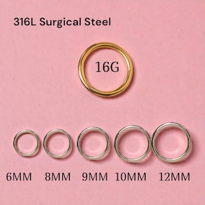 May include: A collection of surgical steel body jewelry rings in various sizes. The image shows a gold-colored 16G ring and several silver-colored rings labeled 6MM, 8MM, 9MM, 10MM, and 12MM. The text "316L Surgical Steel" is at the top.