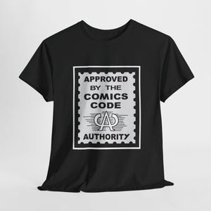 Peut inclure: T-shirt noir avec un graphique blanc d'un timbre qui dit "APPROVED BY THE COMICS CODE AUTHORITY".