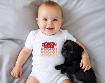 May include: A white short-sleeved baby bodysuit featuring a red graphic of a pug face above the text PUGTOT repeated three times in a stacked, retro-style font with gradient colours ranging from red to orange and yellow.