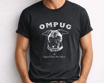 May include: A black short-sleeved t-shirt featuring a white graphic of a pug wearing a spiked collar. The text OMPUG is printed above the dog, and the text the Original Punk Rock Breed is printed below the dog in a white, distressed font.