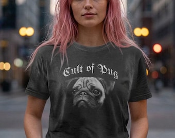 May include: A charcoal grey short-sleeve t-shirt featuring a black and white graphic of a pug dog face centred on the chest. Above the dog image, the text Cult of Pug is printed in a white, distressed, gothic-style font.