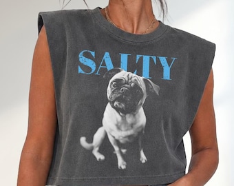 May include: A charcoal grey sleeveless crop top with padded shoulders. The shirt features a black and white photographic print of a pug dog centred on the front, with the word SALTY printed in distressed light blue capital letters above it.