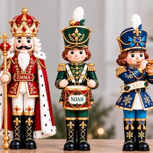 May include: Three decorative nutcracker figurines. The left figure is a king in red robes with the name EMMA. The centre figure is a drummer in green with the name NOAH. The right figure is a musician in blue with the name LILY.