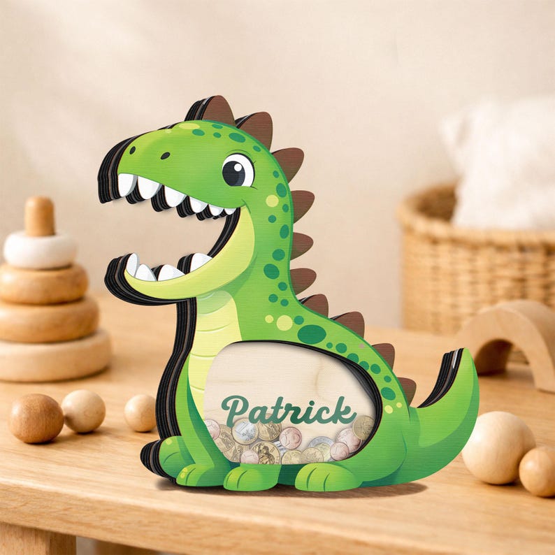 May include: A green dinosaur-shaped wooden coin bank with the name "Patrick" on the front. The bank has a smiling face, brown spikes, and a slot for inserting coins. The bank is filled with coins.