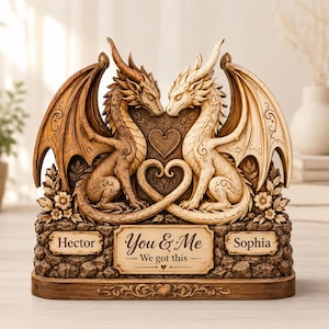 May include: A decorative sculpture featuring two dragons, one dark brown and one cream, facing each other with tails forming a heart. The base includes three plaques with the text Hector, You & Me We got this, and Sophia, surrounded by floral carvings.