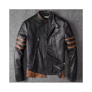May include: Black leather jacket with brown detailing. The jacket has a stand-up collar, a zip closure, and brown stripes on the sleeves. It features two zipped chest pockets and brown trim at the hem.