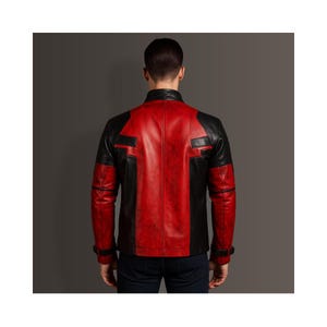 K&ouml;nnte beinhalten: Eine rot-schwarze Lederjacke mit klassischem Design. Die Jacke hat einen roten K&ouml;rper mit schwarzen Eins&auml;tzen an Schultern, &Auml;rmeln und Seiten. Sie hat einen Kragen und einen Rei&szlig;verschluss vorne. Ein stilvolles Oberbekleidungsst&uuml;ck.
